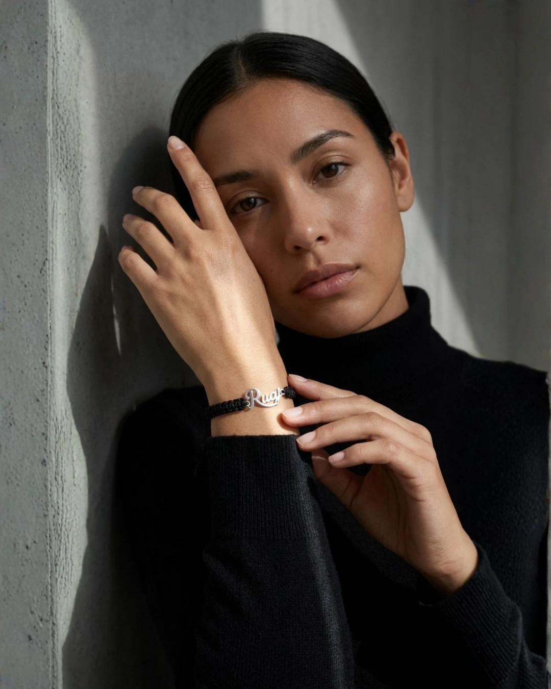 Modelo luciendo la pulsera RUAJ en plata con suéter negro de cuello alto